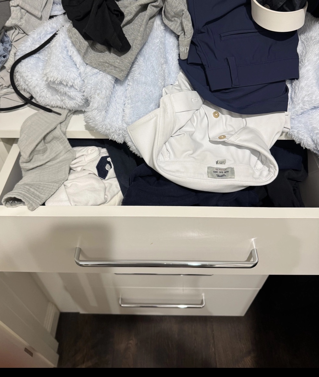 A dresser drawer before: clothes piled and spilling over the edge