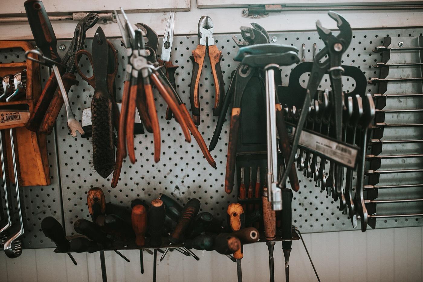 A pegboard of pliers, wrenches and screwdrivers in a workshop